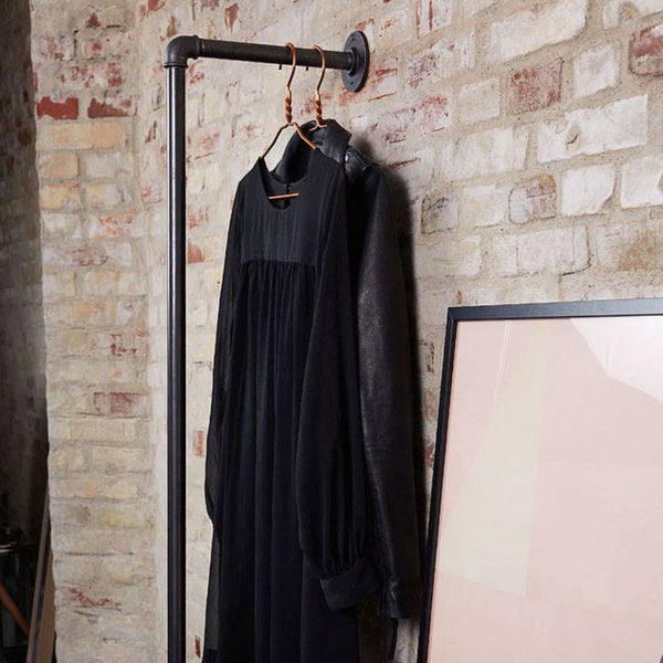 Wall mounted clothes rail with support to the floor made from dark iron pipes