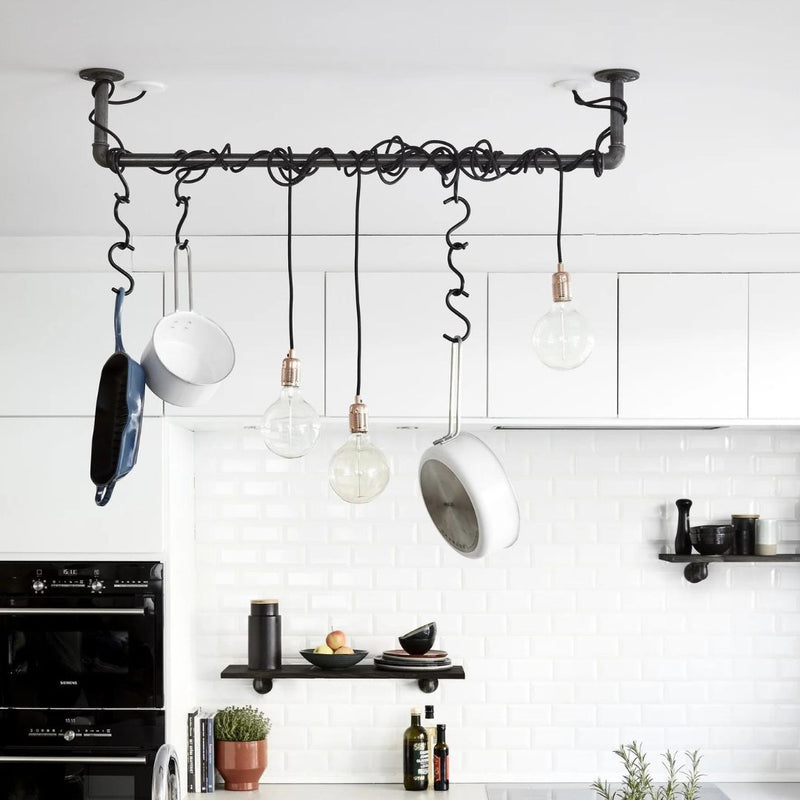 Ceiling mounted dark iron rail used to hang pots and pans and a lot of light blubs functional design